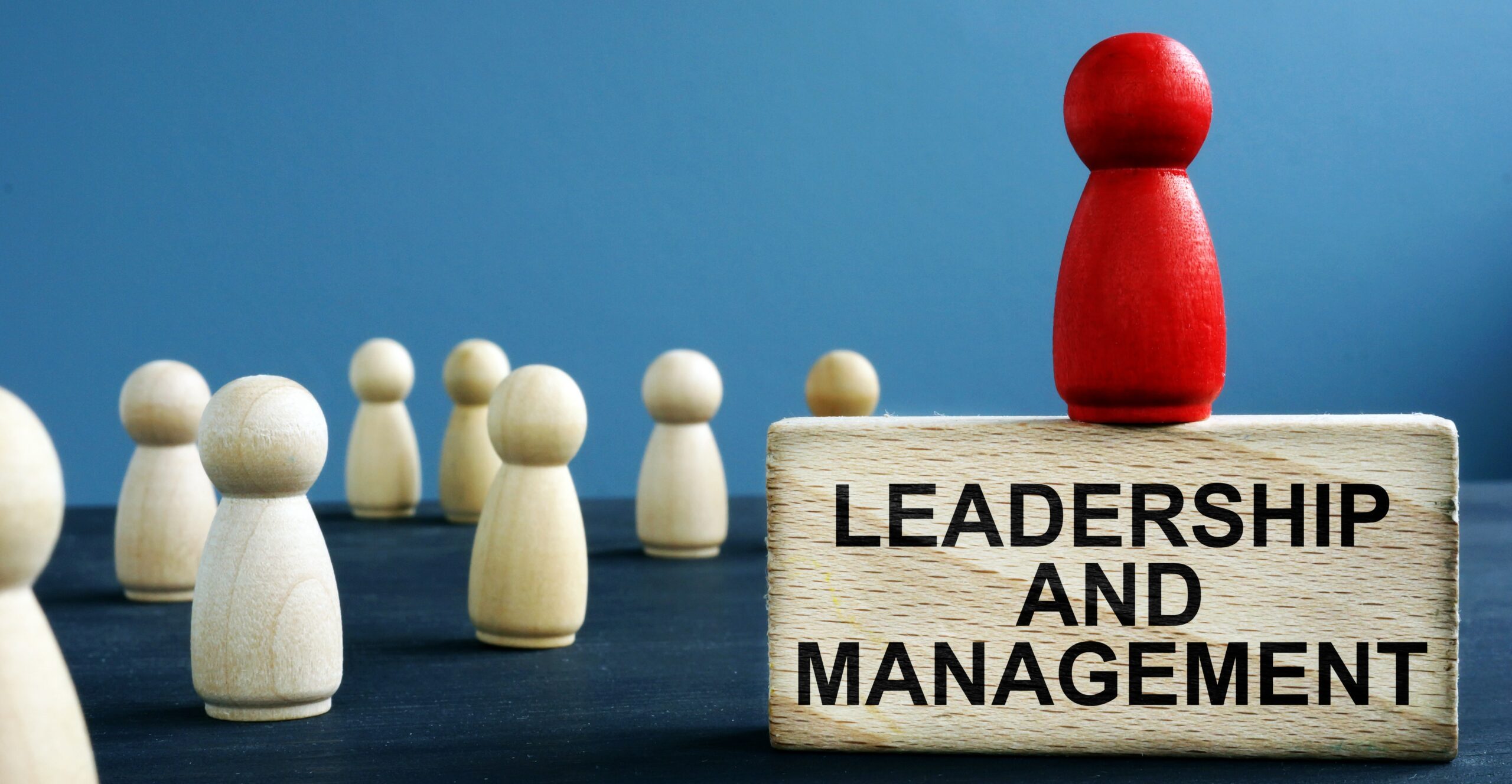 Leadership and management written on a wooden block.